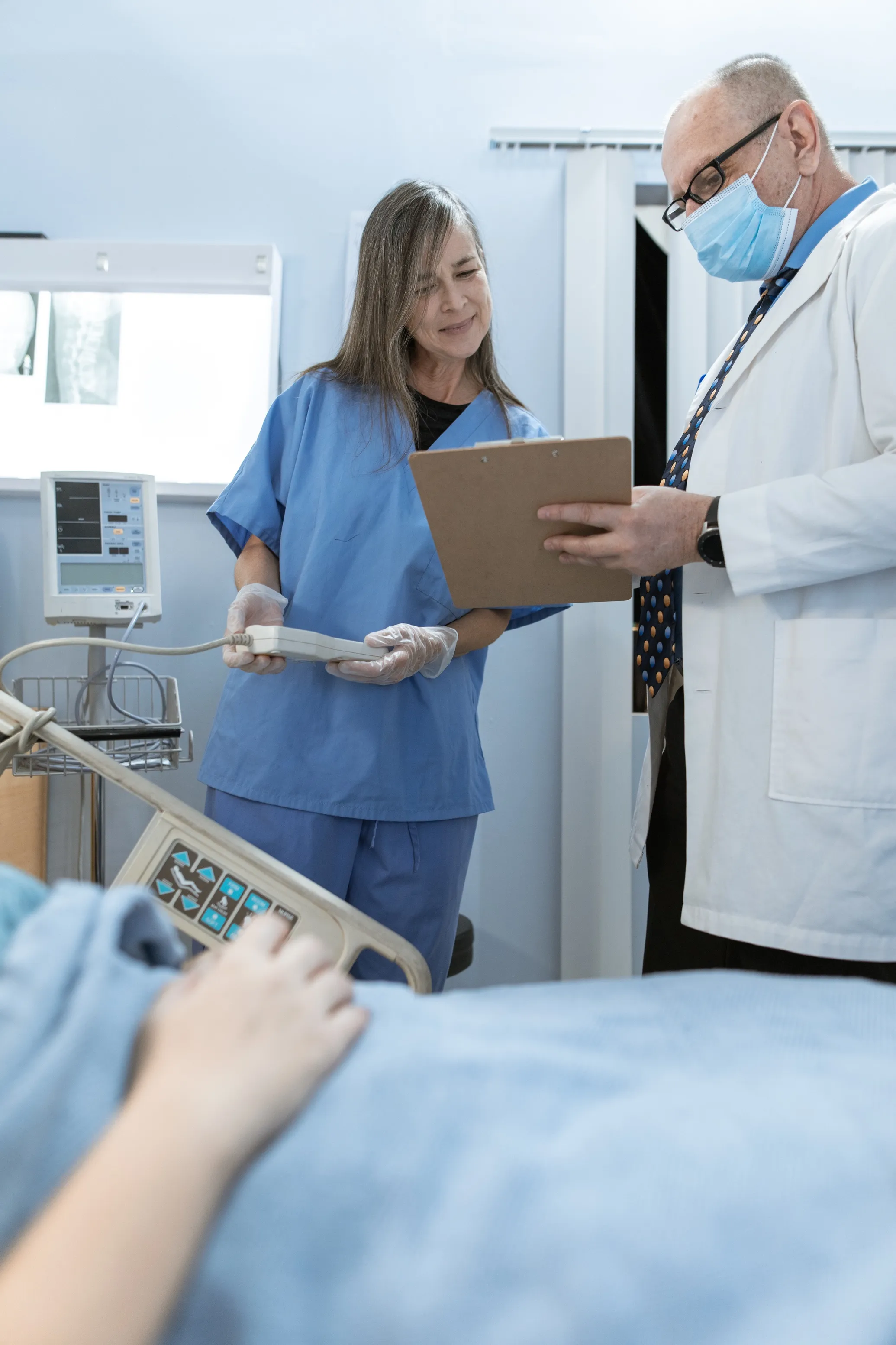 Doctor meeting with nurse near a patient